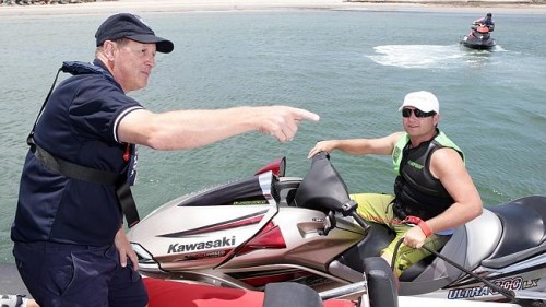 Marine safety officer  David Mattner talks to jet skier Darren Lamp at West Beach. Picture: Calum Robertson